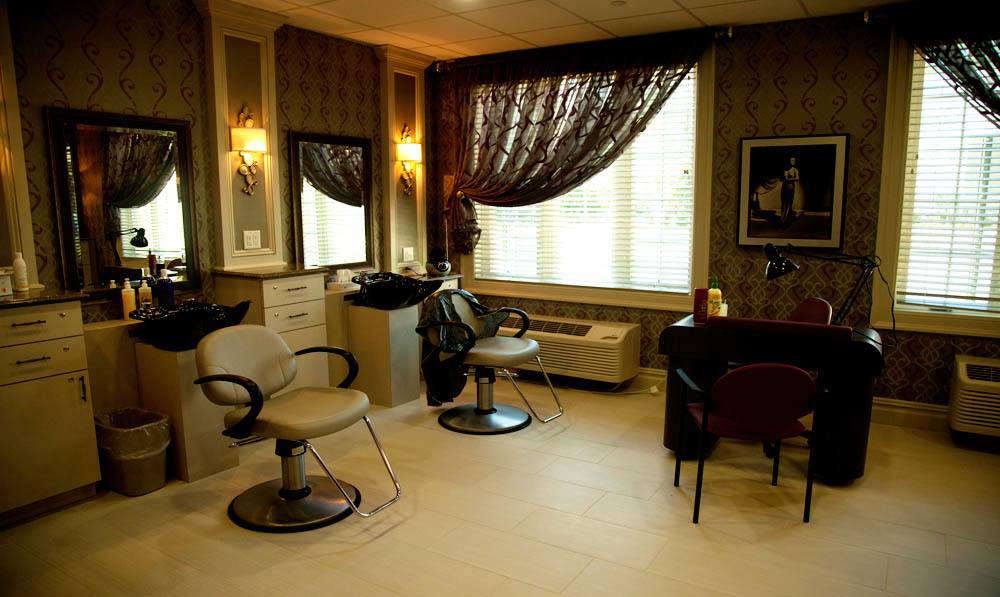 Hairdresser chairs and dryers set by sinks in the Beauty Salon at The Ambassador