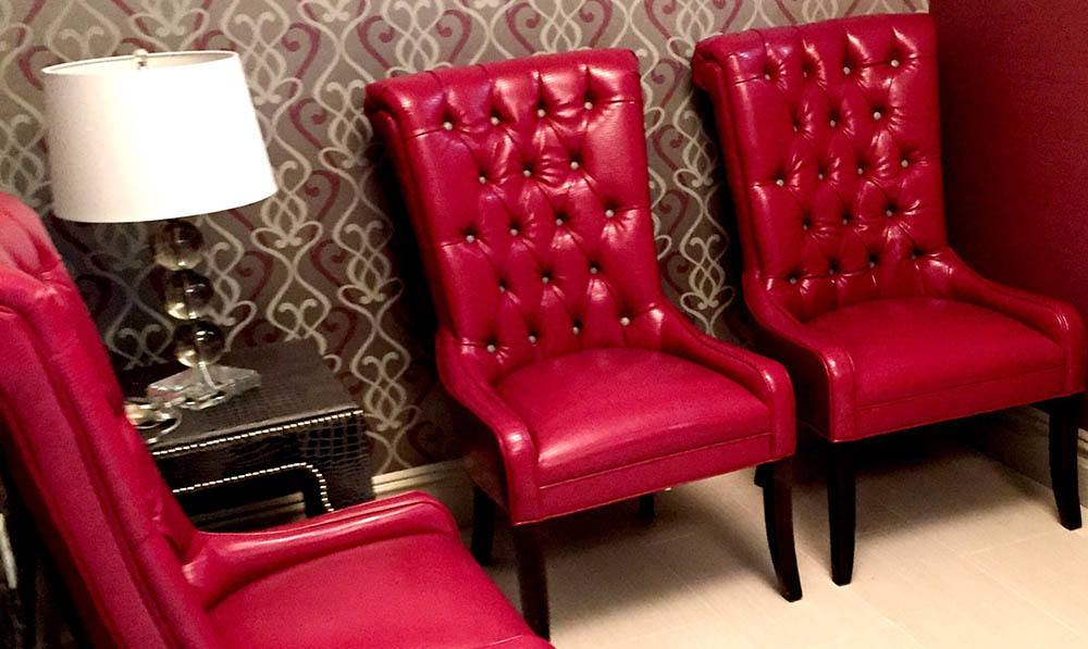 Red leather chairs set up in the waiting area of the Beauty Salon at The Ambassador
