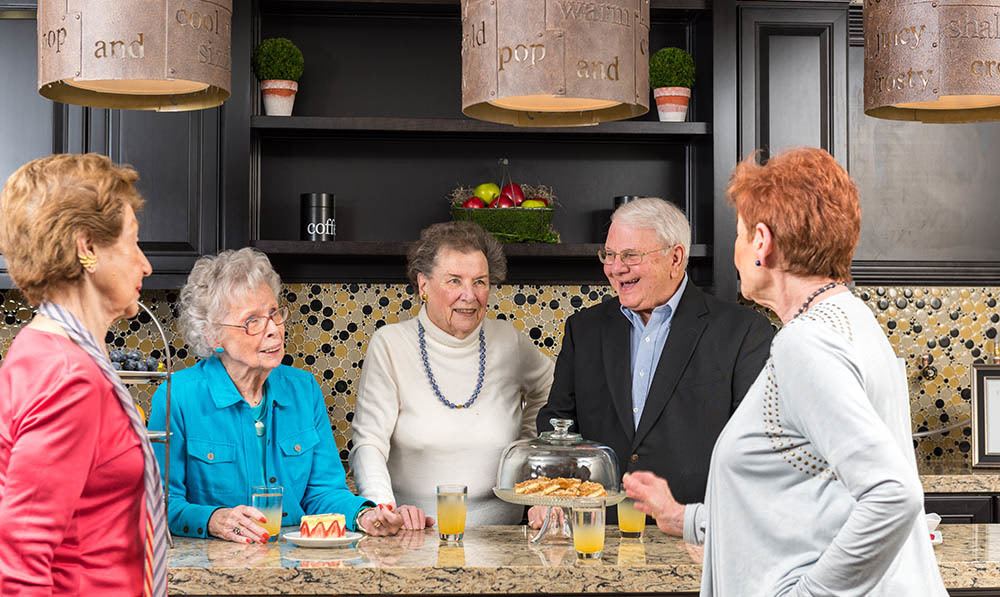 A group of residents drinking coffee and chatting in the Five Corners Bistro at The Ambassador