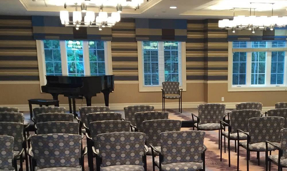 Empty chairs lined up in front of an open piano on stage at The Performing Arts Center at The Ambassador