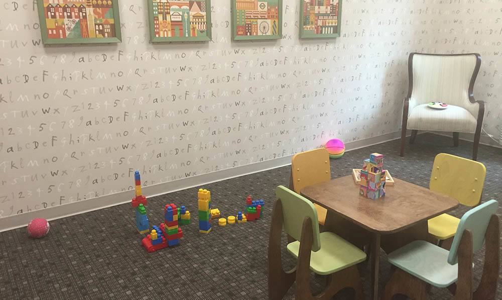 Kids tables and chairs and lego blocks set up in the Rumpus Room at The Ambassador