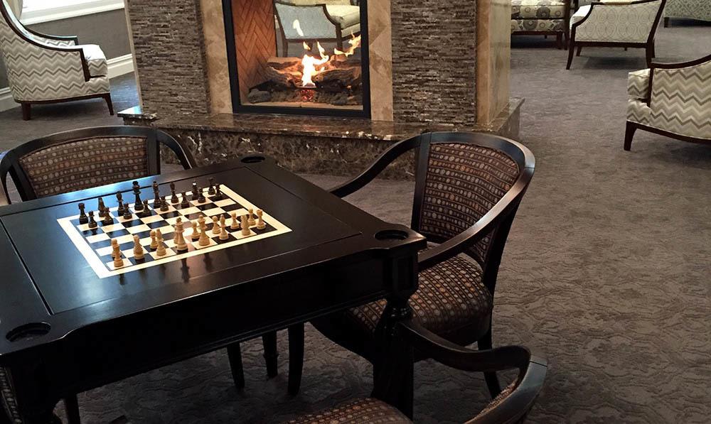 A game of chess set up on a chess board built into a table at the Club Room at The Ambassador