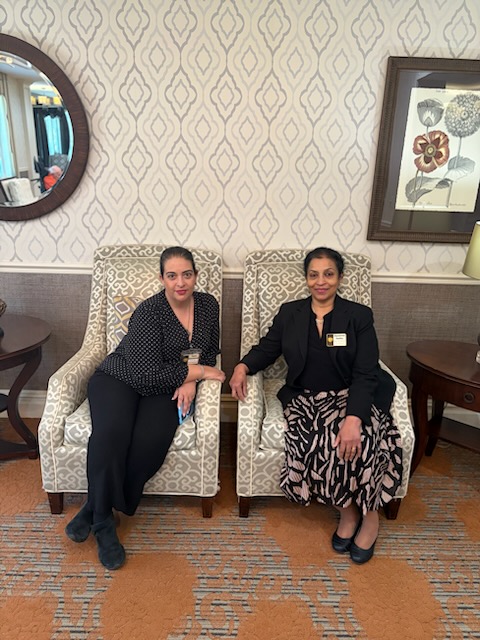 two women sitting on armchairs side by side