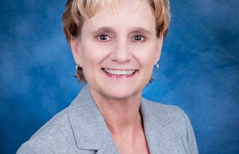 woman in blue suit smiling for the camera