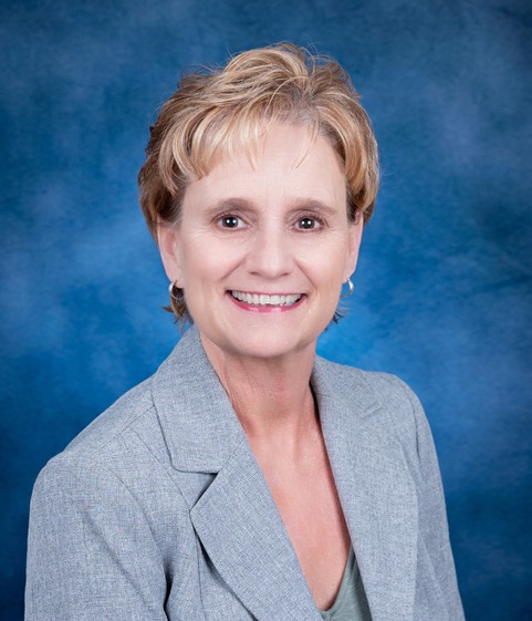 woman in blue suit smiling for the camera